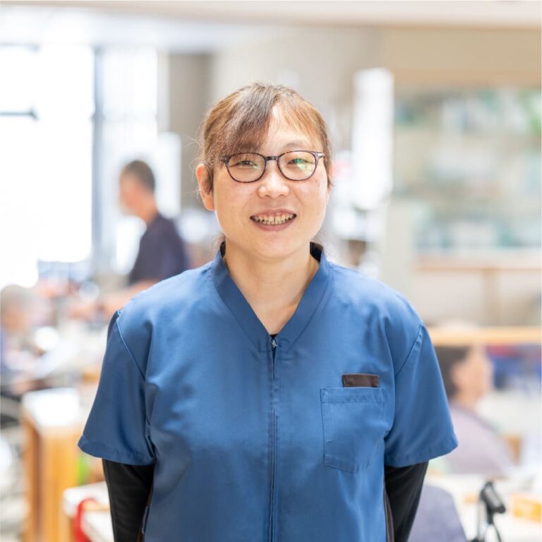 介護職員の笑顔のポートレート。食堂での勤務風景。